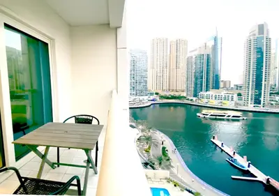 a balcony with a table and a view of a river at Full sea view with balcony - Studio Apartment - 10 min to JBR - in Dubai