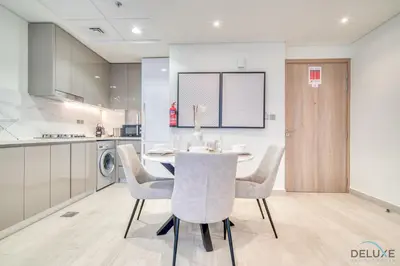 a kitchen and dining room with a table and chairs at Ravishing 2BR at Azizi Riviera 30, Al Merkadh by Deluxe Holiday Homes in Dubai
