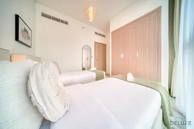 a bedroom with a white bed and a window at Ravishing 2BR at Azizi Riviera 30, Al Merkadh by Deluxe Holiday Homes in Dubai