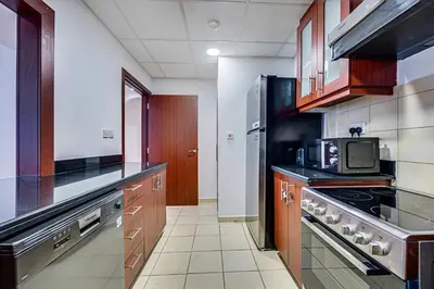 a kitchen with a stove and a microwave at Delightful 2BD apartment near the JBR in Dubai