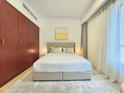 a bedroom with a white bed and a large window at Delightful 2BD apartment near the JBR in Dubai