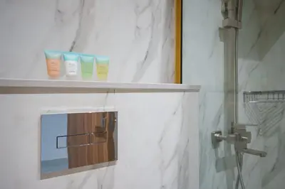 a bathroom with three bottles of moisturizers on a shelf at Studion In Dubailand - Close Kitchen in Dubai