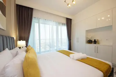 a bedroom with a large white bed with a large window at RH -Skyline Serenity, High-Floor Oasis in Downtown, walk to Burj Khalifa in Dubai