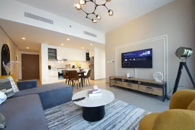 a living room with a couch and a tv at RH -Skyline Serenity, High-Floor Oasis in Downtown, walk to Burj Khalifa in Dubai