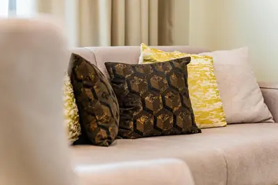 a couch with several pillows on it at SettlerHomes - Sparkle Tower 2 with Stunning Views in Dubai