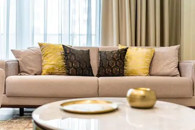 a living room with a couch with pillows and a table at SettlerHomes - Sparkle Tower 2 with Stunning Views in Dubai