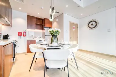 a kitchen and dining room with a table and chairs at Magnificent 2BR at La Voile Jumeirah by Deluxe Holiday Homes in Dubai