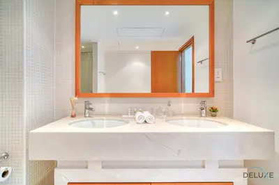 a bathroom with two sinks and a large mirror at Elegant 2BR at Beauport XI Dubai Marina by Deluxe Holiday Homes in Dubai