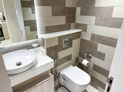 a bathroom with a white toilet and a sink at Seaside 1BR Getaway - Seven Palm in Dubai