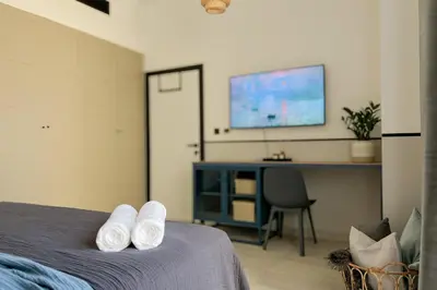 a bedroom with a bed with a desk and a tv at FavDubai presents 2BR apartment in The Heart of JBR and Dubai Marina 150 m to JBR Beach with famous Ain Dubai view the biggest ferris wheel in the world Swimming pool access, air-conditioned gym, free parking & Housekeeping in Dubai