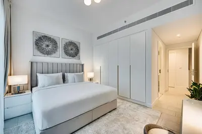 a bedroom with a large white bed and a window at Panoramic sea view from new 2BD in La Vie JBR in Dubai