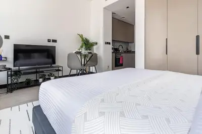 a bedroom with a large white bed and a kitchen at Frank Porter - 15 Northside in Dubai