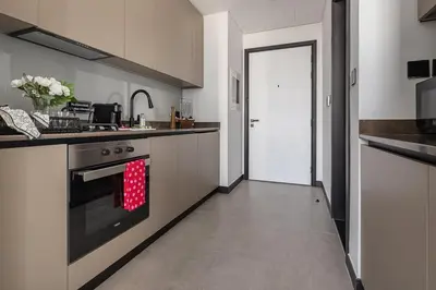 a kitchen with a stove with a red towel on the oven at Frank Porter - 15 Northside in Dubai