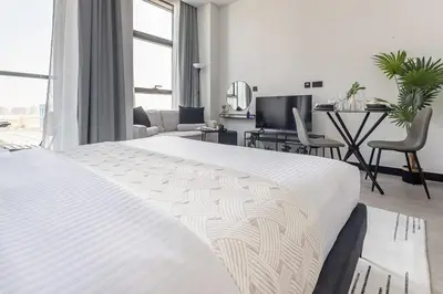 a bedroom with a white bed and a living room at Frank Porter - 15 Northside in Dubai