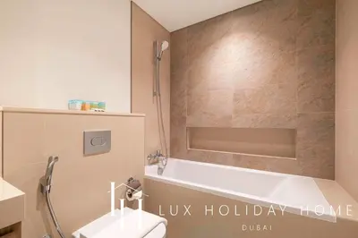 a bathroom with a tub and a toilet and a sink at LUX The Downtown Zabeel View Suite 2 in Dubai