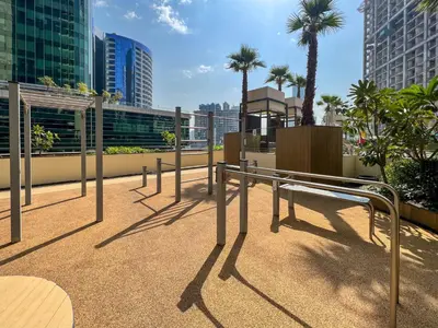 a bench on a balcony with palm trees and buildings at Frank Porter - Ahad Residences in Dubai