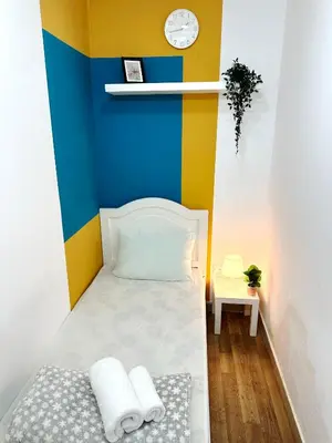 a small room with a bed with a colorful wall at Decent Partition Room in Barsha Heights Near Metro in Dubai