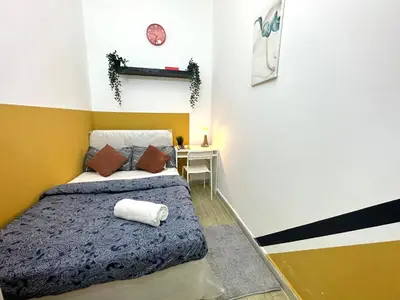 a bedroom with a bed and a desk with a clock at lavish Partition Room in Barsha Heights Near Internet City Metro in Dubai