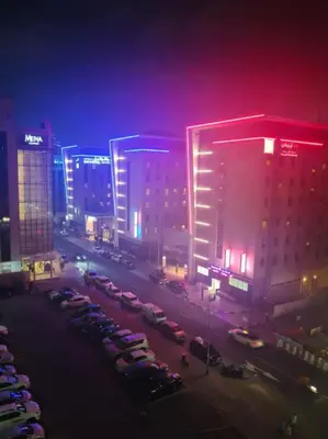 a city at night with cars parked in a parking lot at Fancy Partition Room Near Mashreq Metro / SZ Road in Dubai