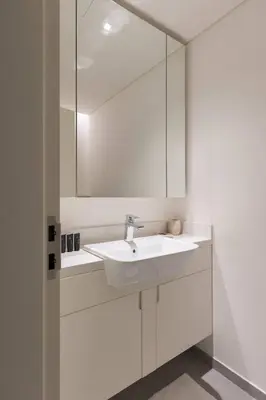 a white bathroom with a sink and a mirror at Ahad Residence Walking Distance to Dubai Mall in Dubai