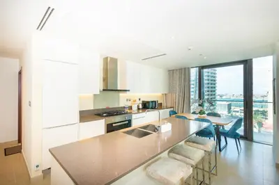 a kitchen with a counter and a table with chairs at HomesGetaway- 2BRLuxury Apartment at Marina Gate 2 in Dubai
