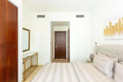 a bedroom with a bed and a mirror and a door at HomesGetaway- 2BRLuxury Apartment at Marina Gate 2 in Dubai