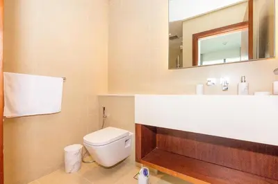 a bathroom with a toilet and a sink and a mirror at HomesGetaway- 2BRLuxury Apartment at Marina Gate 2 in Dubai