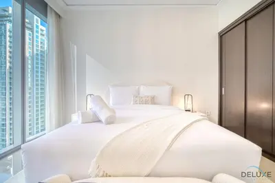 a bedroom with a large white bed with a large window at Plush 2BR at Grand Opera Downtown Dubai by Deluxe Holiday Homes in Dubai