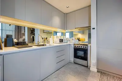 a large kitchen with white cabinets and appliances at Amazing Luxury Studio in Dubai in Dubai