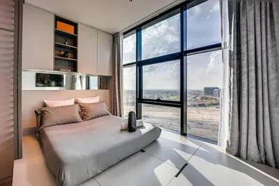 a bedroom with a large bed with a large window at Amazing Luxury Studio in Dubai in Dubai
