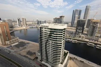 a tall building in a city with a body of water at Business Bay Gem1 bd apt with Scenic Canal Views in Dubai