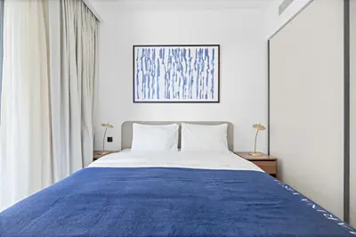 a bedroom with a large bed with a blue blanket at Silkhaus Sea View 1BDR in Marina Vista, near Marina in Dubai