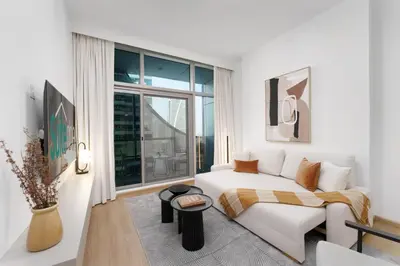 a white room with a bed and a large window at Luxe Living in our Exquisite 1 Bedroom Apartment in Dubai