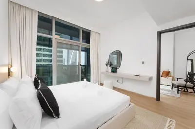 a bedroom with a large white bed and a large window at Luxe Living in our Exquisite 1 Bedroom Apartment in Dubai
