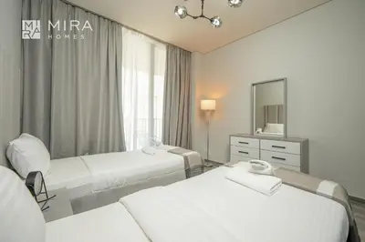 a hotel room with two beds and a mirror at Mira Holiday Homes - Spacious 2 bedroom in Midtown in Dubai