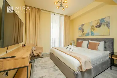 a bedroom with a bed and a desk and a television at Mira Holiday Homes - Spacious 2 bedroom in Midtown in Dubai
