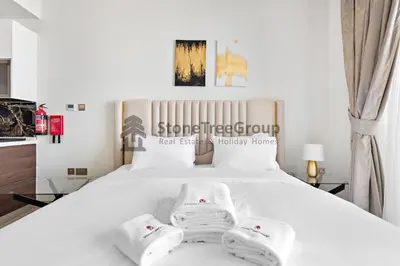 a bedroom with a white bed with towels on it at StoneTree - Brand New Studio in Jewelz Residence in Dubai