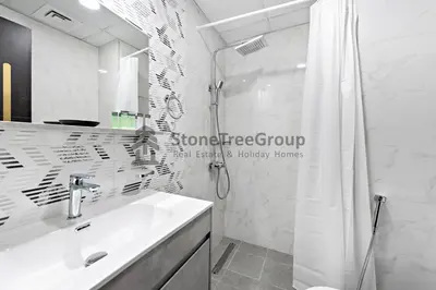 a white bathroom with a sink and a shower at StoneTree - Brand New Studio in Jewelz Residence in Dubai
