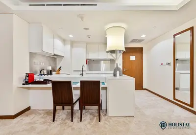 a kitchen with a table and two chairs in it at Kempinski Central Avenue Residence - Direct Access Dubai Mall in Dubai