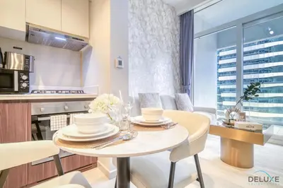 a kitchen and living room with a table and chairs at Special Deal Contemporary 1BR with Canal Views by Deluxe Holiday Homes in Dubai