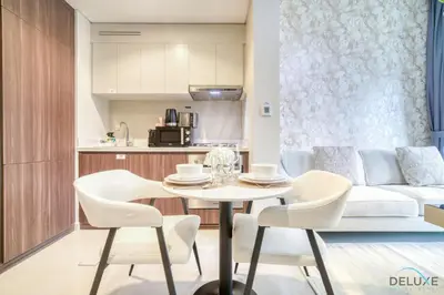 a kitchen and living room with a table and chairs at Special Deal Contemporary 1BR with Canal Views by Deluxe Holiday Homes in Dubai