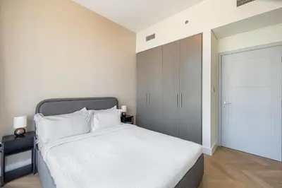 a bedroom with a white bed and a closet at Daniels Luxury 3BR with Dubai Opera Views in Dubai