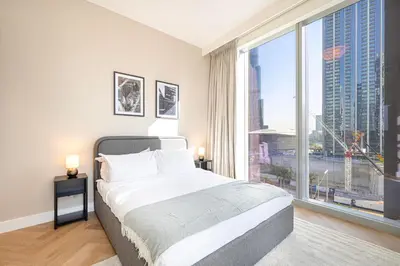 a bedroom with a bed and a large window at Daniels Luxury 3BR with Dubai Opera Views in Dubai