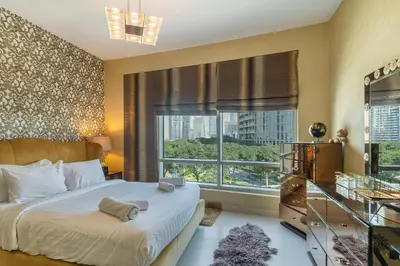 a bedroom with a bed and a large window at Close to Metro - Classic 2BR in Loft East,Downtown in Dubai
