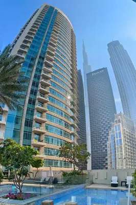 a tall building with a pool in front of a city at Close to Metro - Classic 2BR in Loft East,Downtown in Dubai