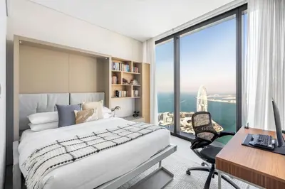 a bedroom with a bed and a desk with a computer at GuestReady - Sky-High Dubai Dreamscape in Dubai