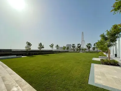 a park with green grass and a bridge in the background at GuestReady - Sky-High Dubai Dreamscape in Dubai