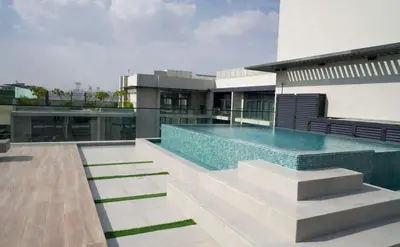 a swimming pool on the side of a building at Cosy 1BR in the center of JVC in Dubai