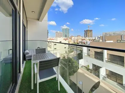a balcony with a table and a view of a city at Cosy 1BR in the center of JVC in Dubai