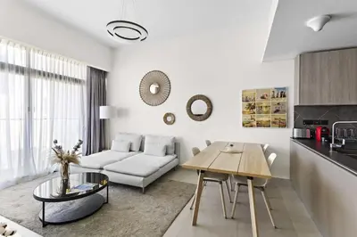 a living room with a couch and a table at Cosy 1BR in the center of JVC in Dubai